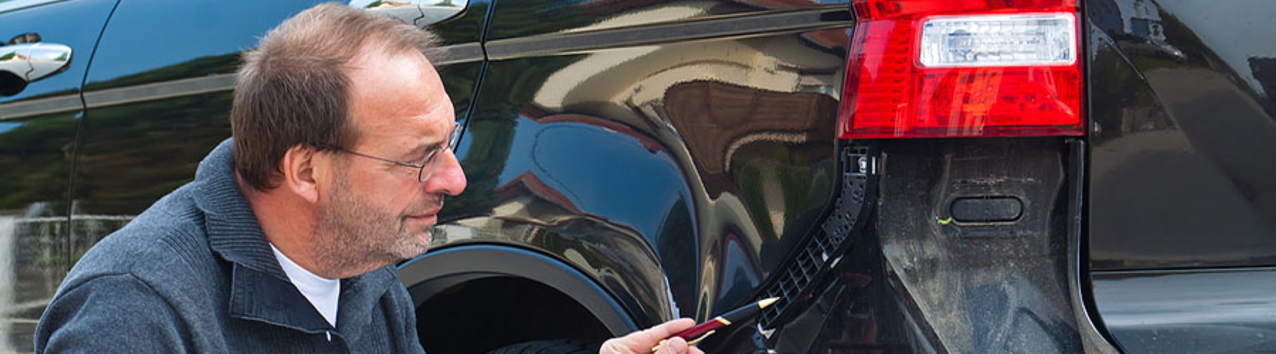 man pointing out damage on a vehicle